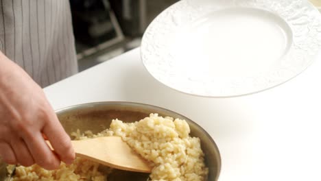 Cook-serving-Parmesan-risotto-on-plate
