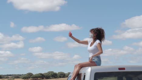 Content-woman-taking-selfie-on-roof-of-car
