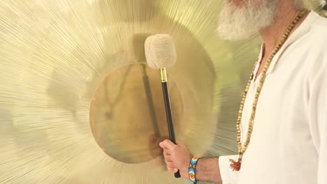 Crop-spiritual-practitioner-with-hammer-playing-gong