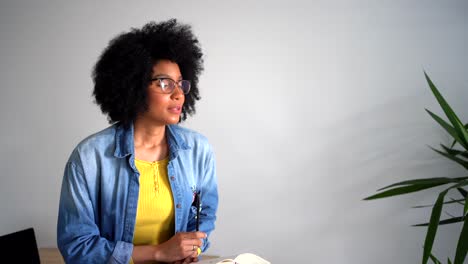 Mujer-Negra-Positiva-Hablando-Con-Una-Persona-Y-Tomando-Notas-En-Un-Cuaderno