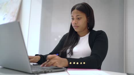 Ernsthafte-Schwarze-Frau,-Die-Im-Büro-Am-Laptop-Arbeitet