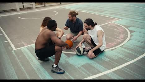 Multiracial-basketball-team-talks-out-your-strategy-on-the-basketball-field-before-the-game-starts