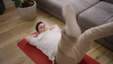 Portrait-of-a-guy-with-down-syndrome-doing-home-workouts-on-the-floor