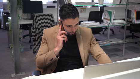 Businessman-talking-on-smartphone-in-office