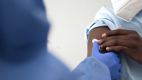 Female-doctor-preparing-to-vaccinate-black-male-patient