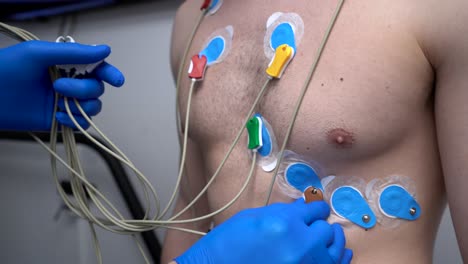 Crop-doctor-connecting-electrodes-to-chest-of-patient-for-ECG