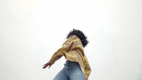 Energetic-black-woman-dancing-on-concrete-border