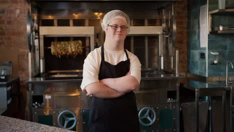 Worker-with-Down-syndrome-with-crossed-arms-standing-at-doner-kebab-cafe-in-apron
