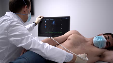 Doctor-examining-heart-of-patient-with-ultrasound-equipment