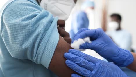 Ärztin-Bereitet-Sich-Auf-Die-Impfung-Eines-Schwarzen-Männlichen-Patienten-Vor