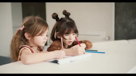 Zwei-Kleine-Kinder-Am-Tisch-Zeichnen-Mit-Buntstiften