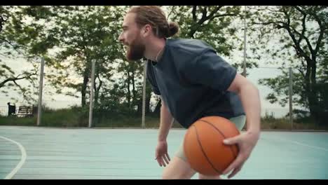 Red-haired-man-in-a-gray-T-shirt-dribbles-an-orange-basketball.-His-opponents-try-to-take-the-ball-away-from-him,-but-the-men-manage-to-protect-him