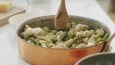 Crop-woman-mixing-pasta-in-sauce-pan