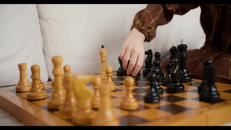 Nahaufnahme-Der-Hände-Eines-Kleinen-Mädchens,-Das-Mit-Schachfiguren-Aus-Holz-Spielt,-Kluges-Kind