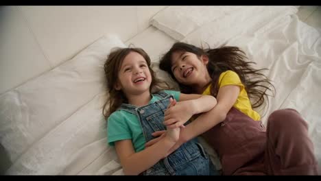 Mädchen,-Freunde-Oder-Kinder-Auf-Weißem-Bett-Beim-Gemeinsamen-Entspannen-Und-Spielen,-Draufsicht