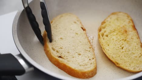 Anonymous-person-frying-bread-slices-in-pan