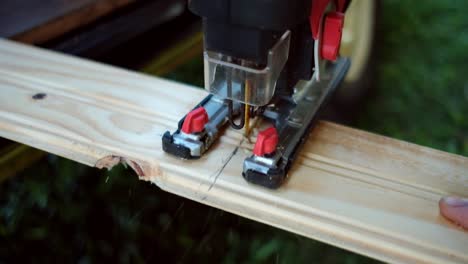 Crop-craftsman-cutting-wooden-board-near-van