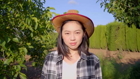 Asian-farmer-comparing-whole-and-bad-pear-in-countryside
