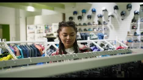 Woman-shopping-choosing-sports-pants-in-sport-clothing-store