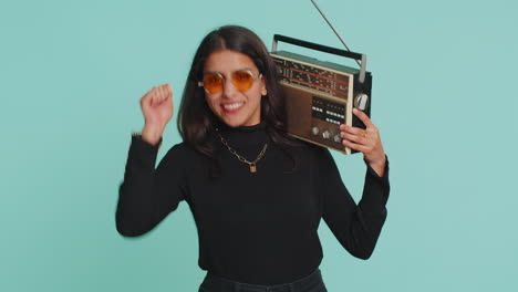 Indian-woman-using-retro-tape-record-player-listen-music-disco-dancing-of-favorite-track-having-fun
