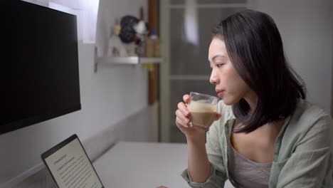 Asian-writer-with-laptop-and-coffee-at-home