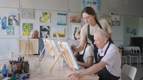 Like-senior-friends-attending-together-at-a-painting-class.-small-group-taking-a-variety-of-fun-classes-together.-A-group-of-elderly-people-attend-a-master-class-on-drawing-together-spending-time.