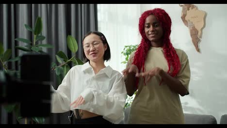 Two-girls-African-American-and-Asian-recording-trendy-dance-moves-for-social-media-account