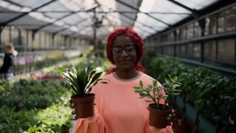 Lovely-african-american-woman-walking-with-plants-in-the-greenhouse
