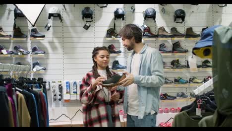 Young-couple-discuss-to-buy-the-shoes-or-not-in-the-sport-store-together