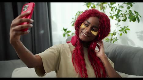 Junge-Schöne-Afrikanische-Frau-Mit-Augenklappen,-Die-Mit-Dem-Handy-Ein-Selfie-Foto-Macht