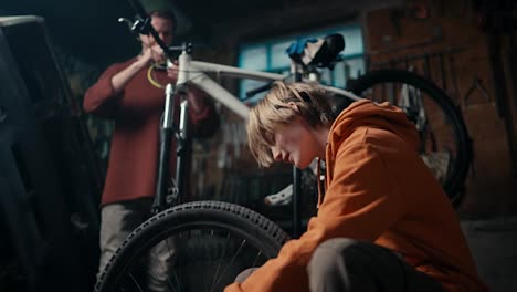 Father-foreman-and-his-son-assistant-work-on-bicycle-repair-in-workshop.-Father-Son-Bonding:-The-Joy-of-Bike-Repair