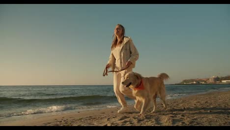 Ein-Morgendlicher-Lauf-Eines-Jungen-Blonden-Mädchens-Und-Ihres-Hundes-In-Heller-Farbe-An-Einem-Sonnigen-Strand-Am-Morgen