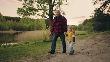 old-man-and-grandchild-are-spending-time-together-in-nature-grandfather-and-boy-on-shore-of-lake