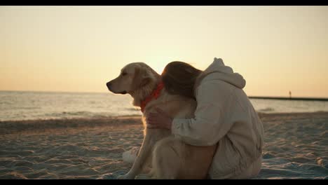 Blonde-girl-petting-her-dog-on-the-beach-in-the-morning.-Sunny-morning,-beautiful-transfusion-of-sunlight