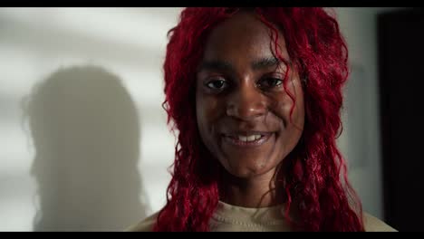Portrait-of-a-happy-carefree-african-american-woman-with-red-colored-hair,-smiling-to-the-camera