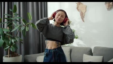Hermosa-Chica-Asiática-Con-Tatuajes-Disfruta-Escuchando-Música-Y-Bailando-En-Casa.