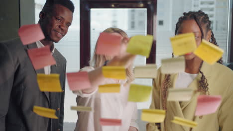 teamwork-and-brainstorming-in-in-office-of-big-company-portrait-of-workers-through-post-it-notes
