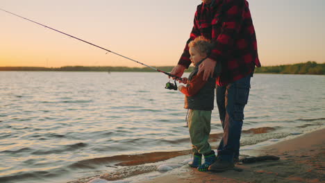 El-Niño-Está-Aprendiendo-A-Pescar,-Pescando-Con-Carretes-De-Caña-De-Pescar.-El-Niño-Feliz-Y-Su-Padre-Pasan-El-Fin-De-Semana-Juntos.