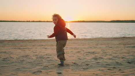 smiling-little-boy-is-running-on-beach-in-sunset-time-having-fun-in-nature