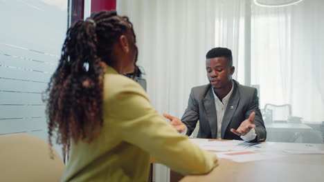 Happy-confident-black-woman-recruit-handshaking-employer-getting-hired-at-new-job.-Smiling-young-female-professional-manager-shake-hand-of-black-man-client-or-customer-making-business-office-meeting