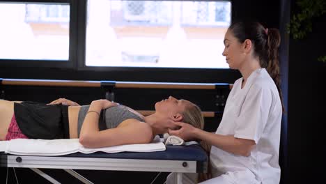 Female-therapist-massaging-head-of-patient