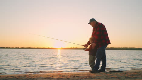 Glücklicher-Opa-Und-Kleiner-Junge-Angeln-Im-Sonnenuntergang.-Alter-Fischer-Und-Enkel-Fangen-Fische