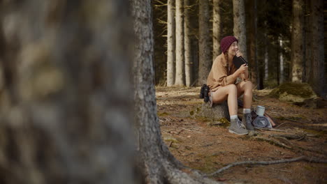 Female-explorer-sitting-with-diary-on-tree-stump
