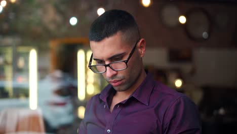Hispanic-male-entrepreneur-reading-notes-in-cafe