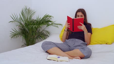 Junge-Frau-Sitzt-Auf-Dem-Bett-Und-Liest-Ein-Buch