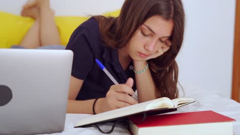 Young-woman-studying-online-in-bedroom