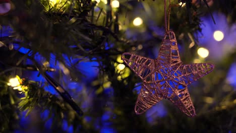 Star-shaped-toy-hanging-on-branch-of-Christmas-tree