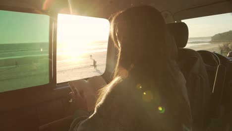 Mujer-Viajera-Leyendo-Un-Libro-En-Una-Camioneta-Al-Atardecer