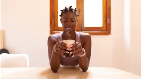 Content-black-woman-with-healthy-drink-at-home