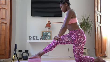 Mujer-Negra-Practicando-Yoga-En-Pose-De-Estocada-Creciente-Durante-La-Clase-En-Línea